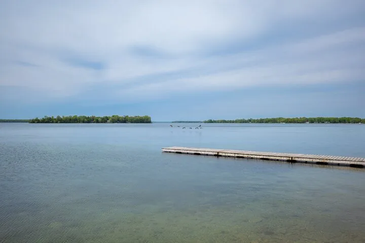 Pontile in legno su un lago calmo sotto un cielo nuvoloso